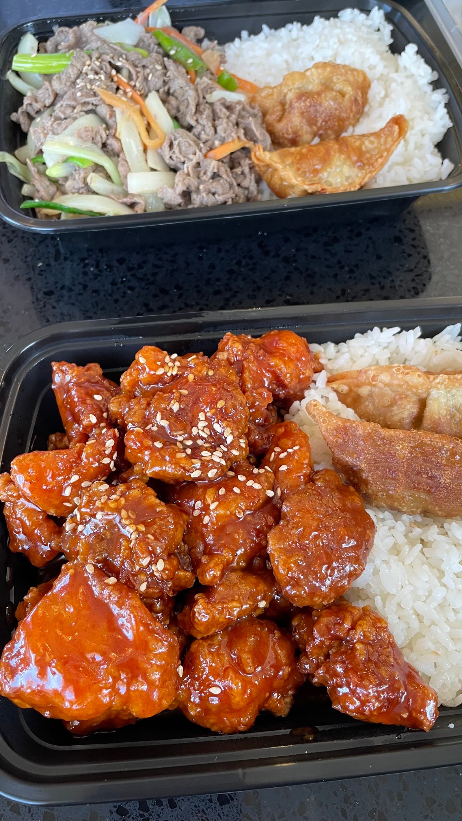 Takeout boxes of spicy chicken with rice and bulgogi